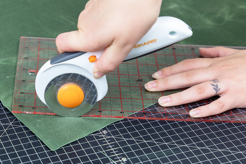 cutting the corner off a waxed canvas piece with a rotary cutter